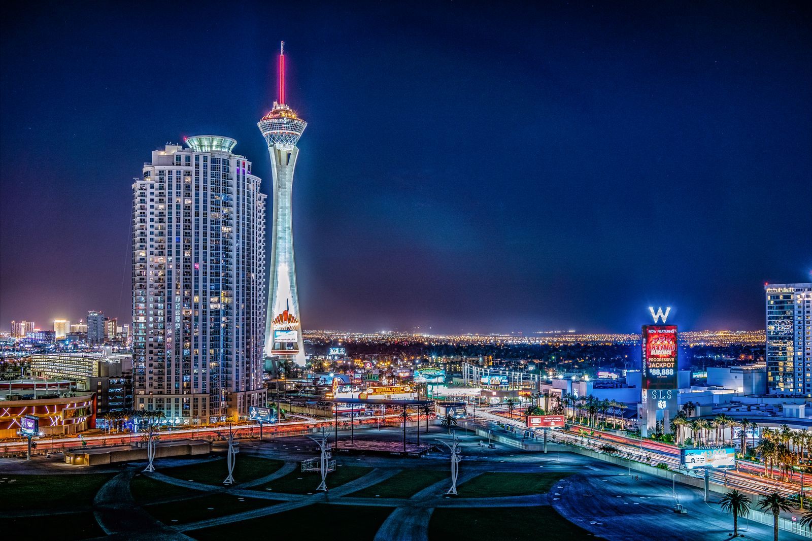 The STRAT tower and Strip resorts lit up at night in Las Vegas