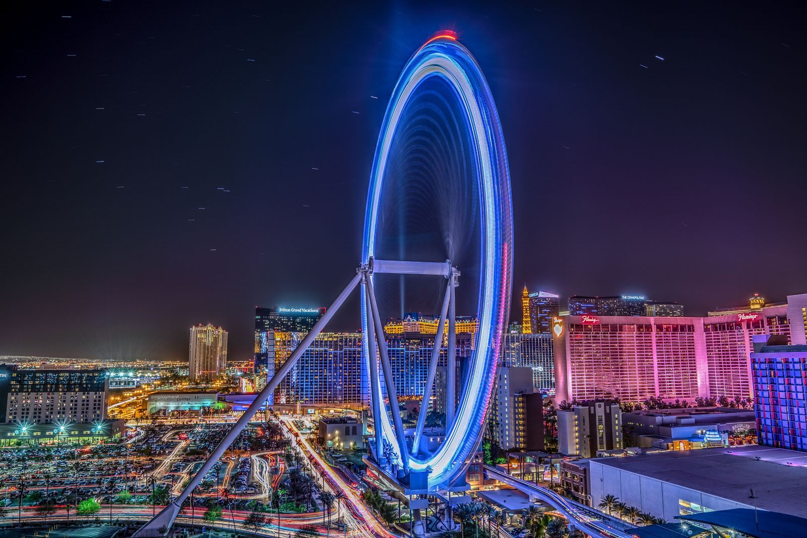 The High Roller observation wheel lit in blue at night, a favorite ride for families seeing Las Vegas with kids